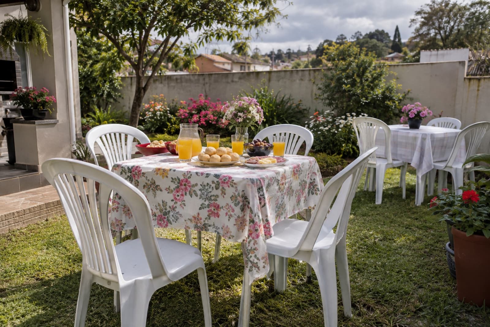 Encontro de primavera no quintal em Curitiba com mesa quadrada florida e cadeiras brancas alugadas
